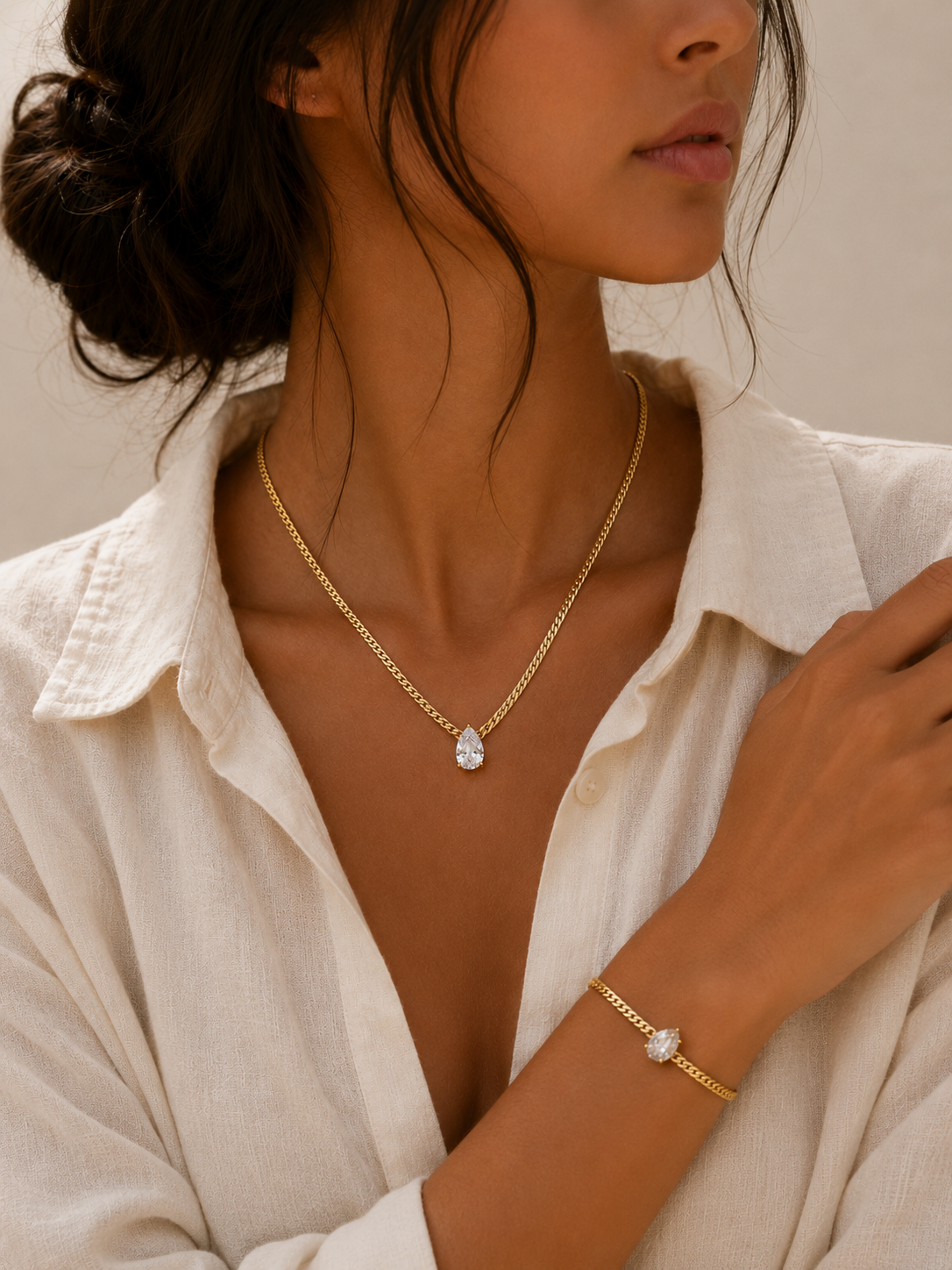 Woman wearing the Adeline Gold Bracelet with a brilliant pear-cut white zircon stone by Maison Élyséa