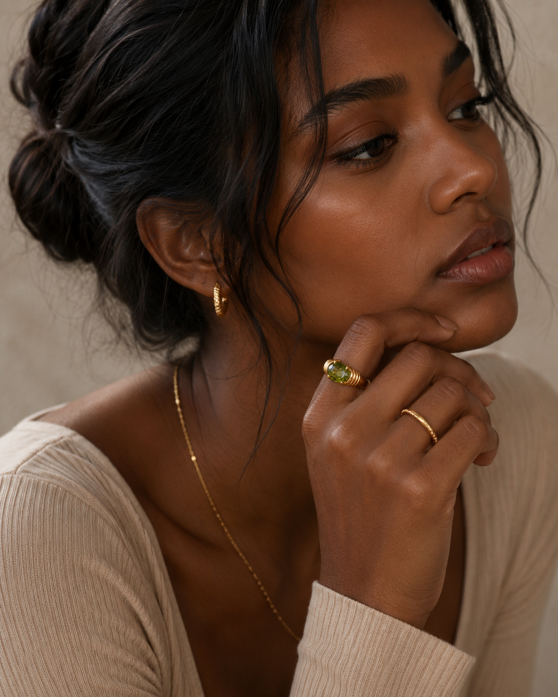 Woman wearing the Naomi Ring with a vibrant green zircon stone in a gold PVD stainless steel setting by Maison Élyséa