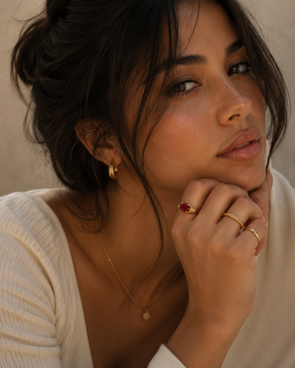 Woman wearing the Naomi Ring with a radiant red zircon stone in a gold PVD stainless steel setting by Maison Élyséa